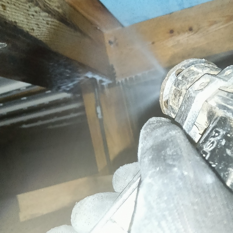 床下の木材にシロアリ駆除剤を散布する様子