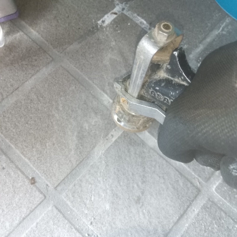 玄関の床にシロアリ駆除剤を注入する様子