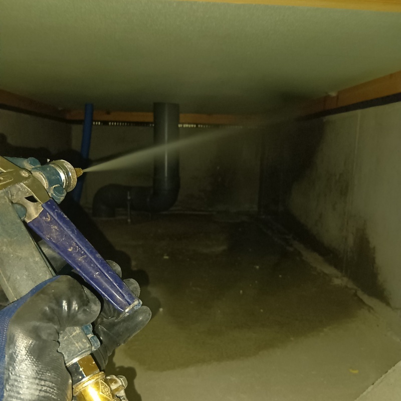 床下の基礎部分に防蟻剤を散布する様子