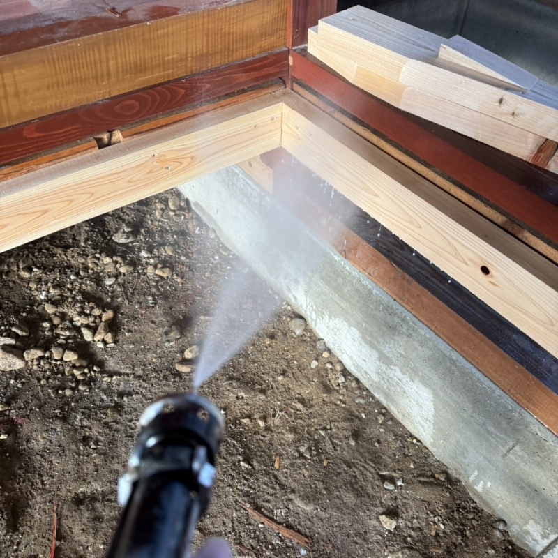 床下の木材にシロアリ駆除剤を散布する様子