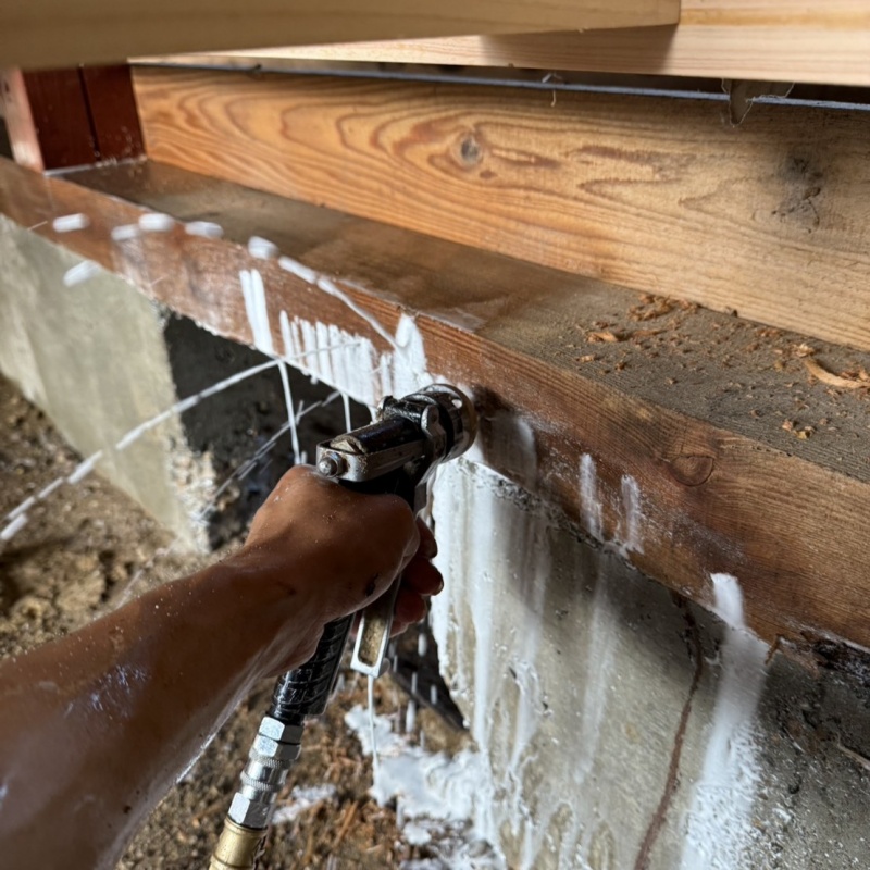 床下の木材にシロアリ駆除剤を注入する様子