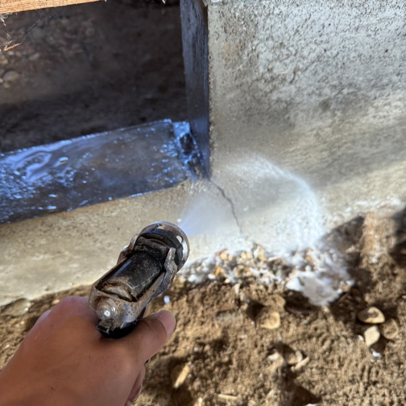 床下の基礎部分にシロアリ駆除剤を散布する様子