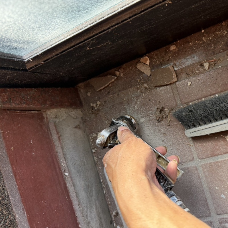 玄関の床にシロアリ駆除剤を注入する様子