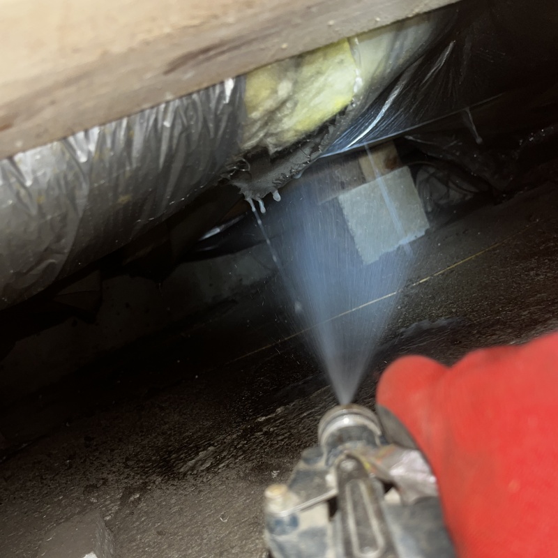 床下断熱材にシロアリ駆除剤を散布する様子