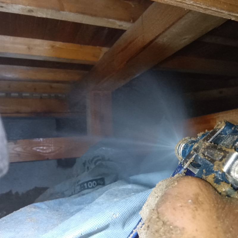 床下の木材にシロアリ駆除剤を散布する様子