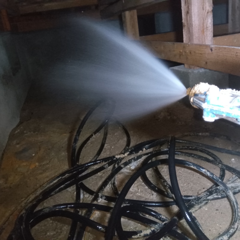 床下の土壌にシロアリ駆除剤を散布する様子