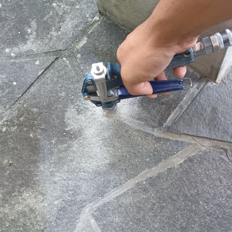 玄関の床にシロアリ駆除剤を注入する様子