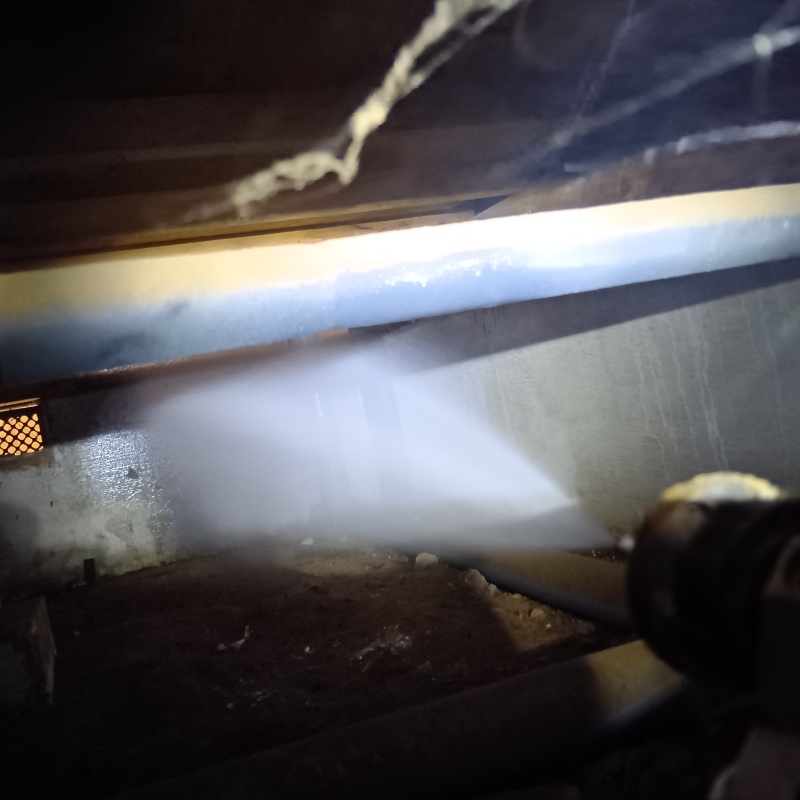 床下の基礎部分にシロアリ駆除剤を散布する様子