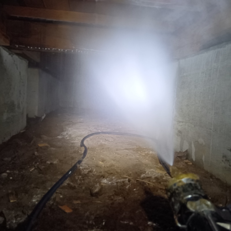 床下の基礎部分にシロアリ駆除剤を散布する様子