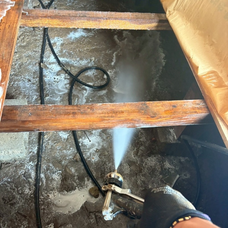 床下の基礎部分にシロアリ駆除剤を散布する様子