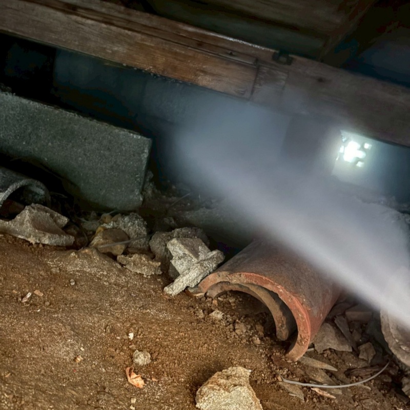 床下の土壌にシロアリ駆除剤を散布する様子