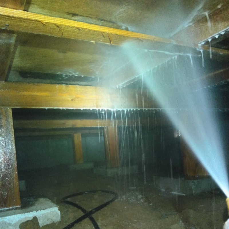 床下の木材にシロアリ駆除剤を散布する様子