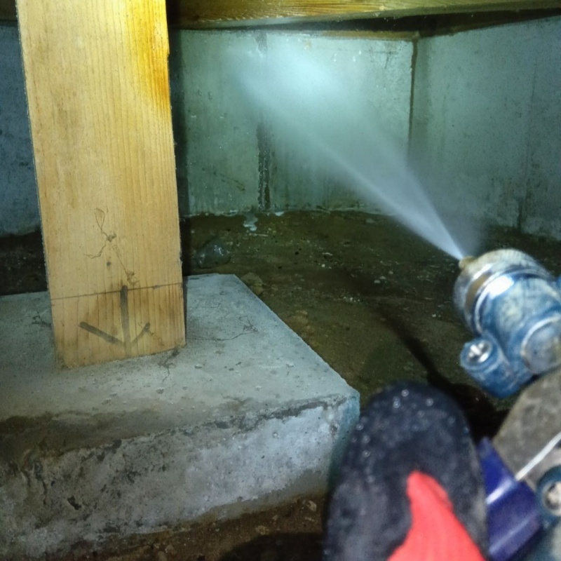 床下の基礎部分にシロアリ駆除剤を散布する様子