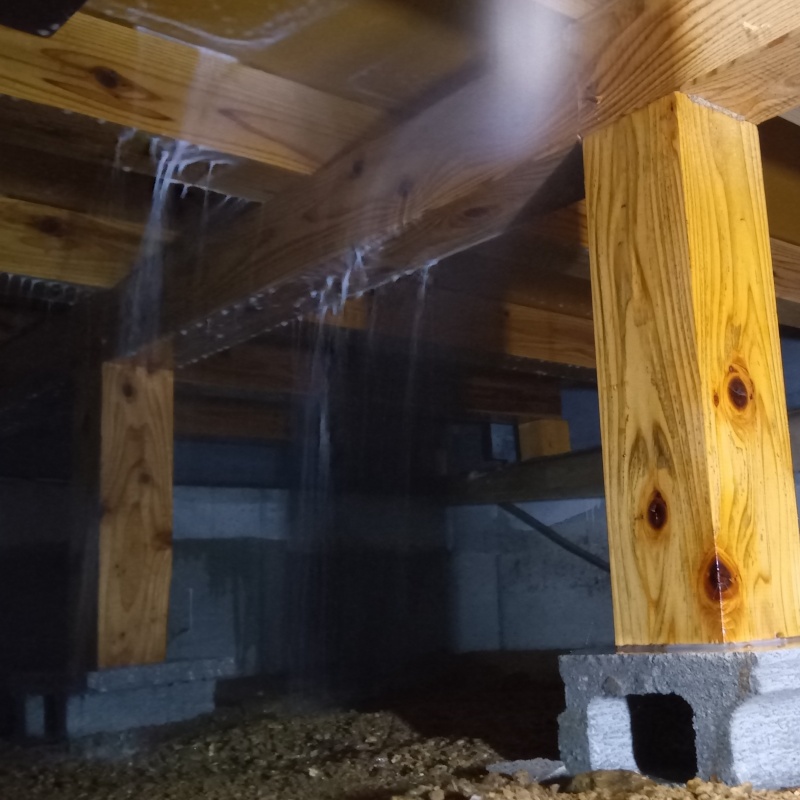 床下の木材にシロアリ駆除剤を散布する様子