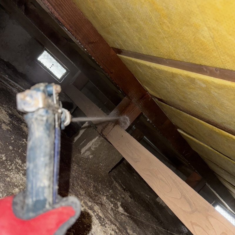 床下の木材にシロアリ駆除剤を散布する様子