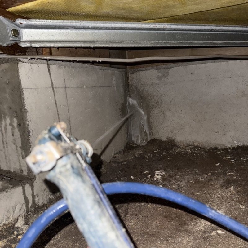 床下の基礎部分にシロアリ駆除剤を散布する様子