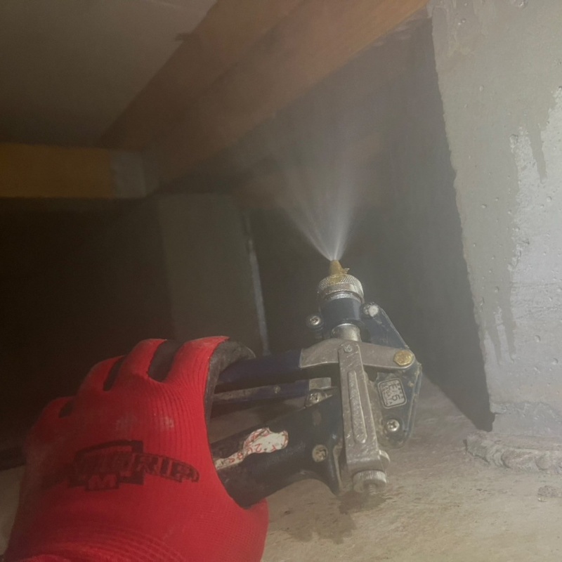 床下の木材に防蟻剤を散布する様子