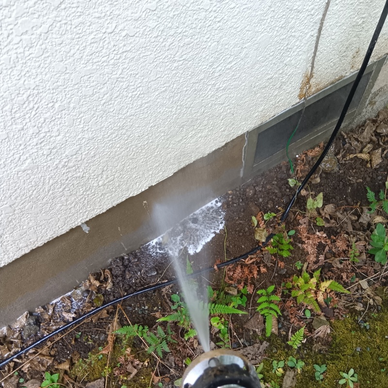 基礎周りにシロアリ駆除剤を散布する様子