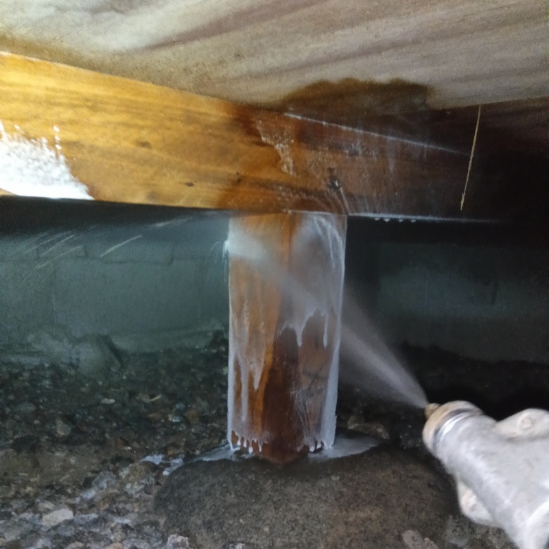 床下の木材にシロアリ駆除剤を散布する様子