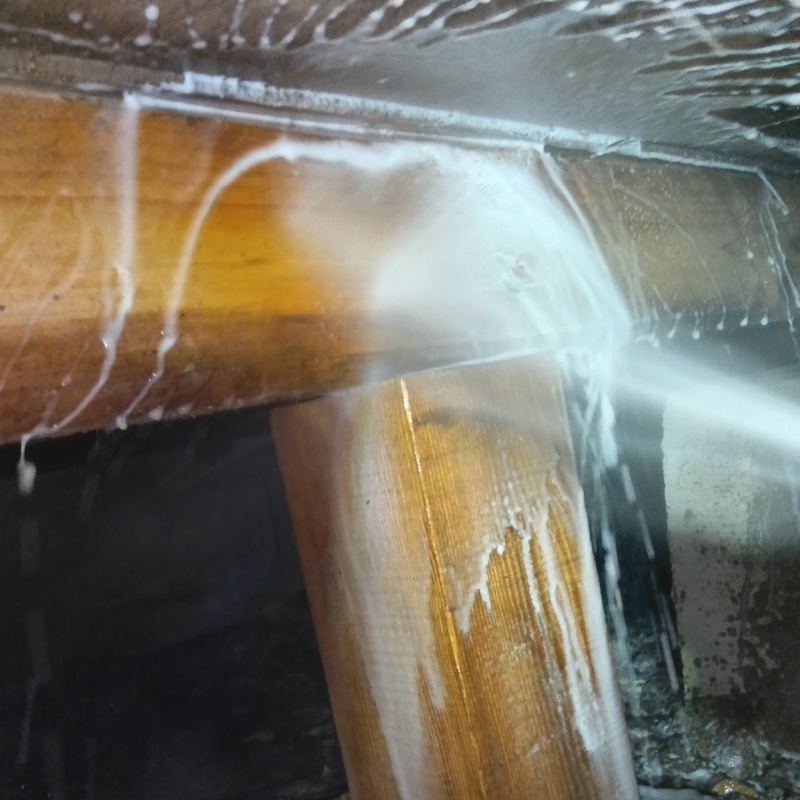 床下の木材にシロアリ駆除剤を散布する様子