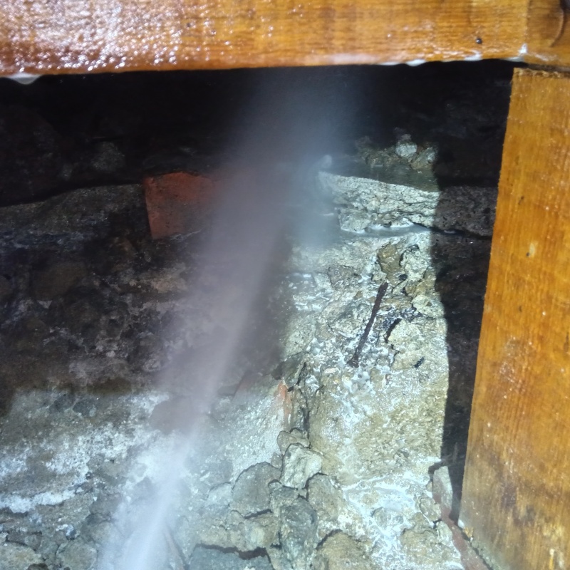 床下の土壌にシロアリ駆除剤を散布する様子