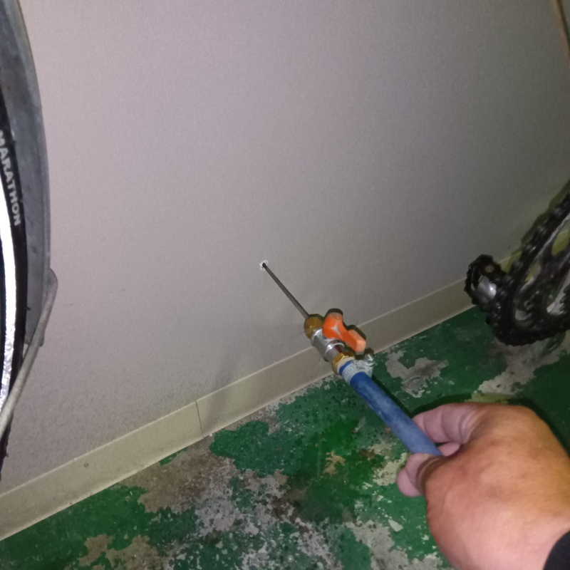 壁にシロアリ駆除剤を注入する様子