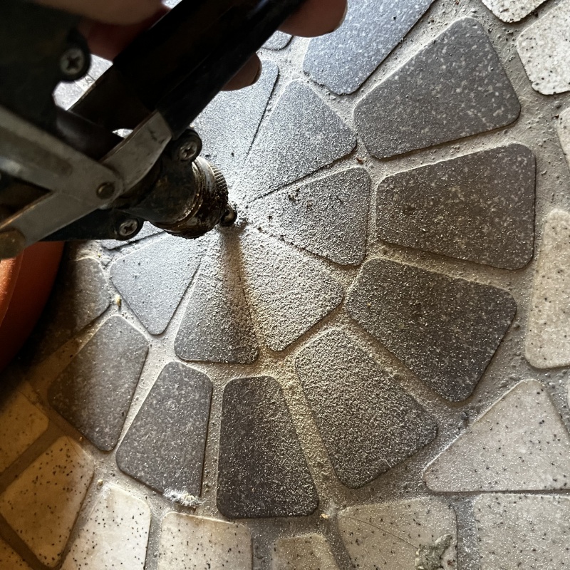 玄関の床にシロアリ駆除剤を注入する様子