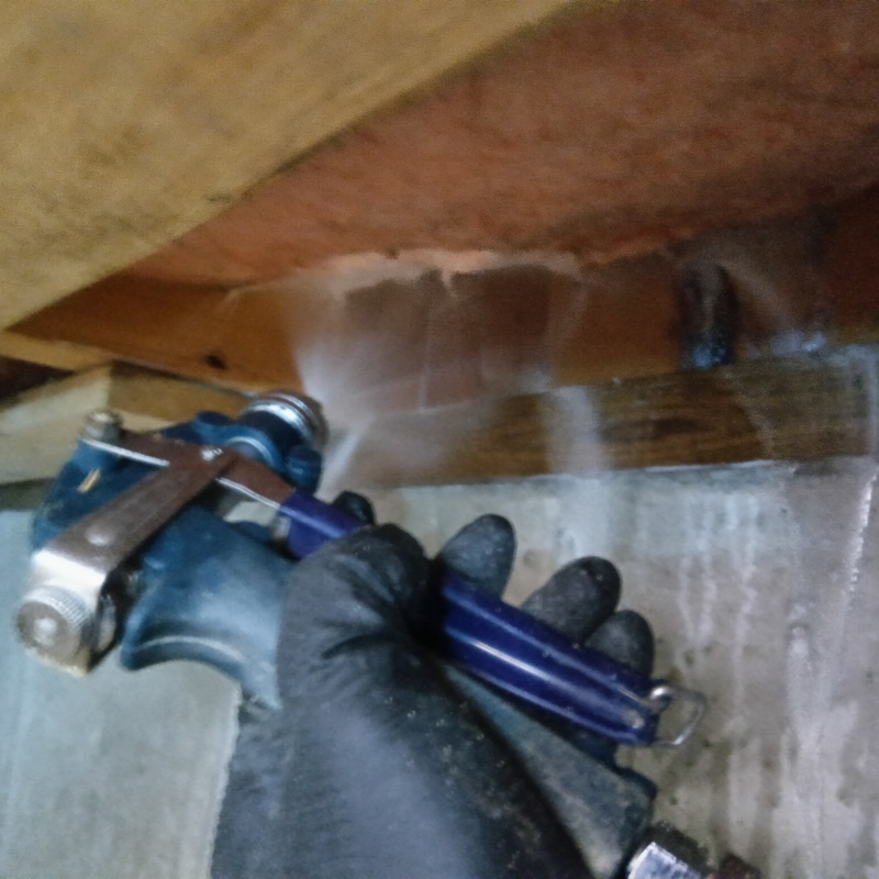 床下の木材にシロアリ駆除剤を散布する様子