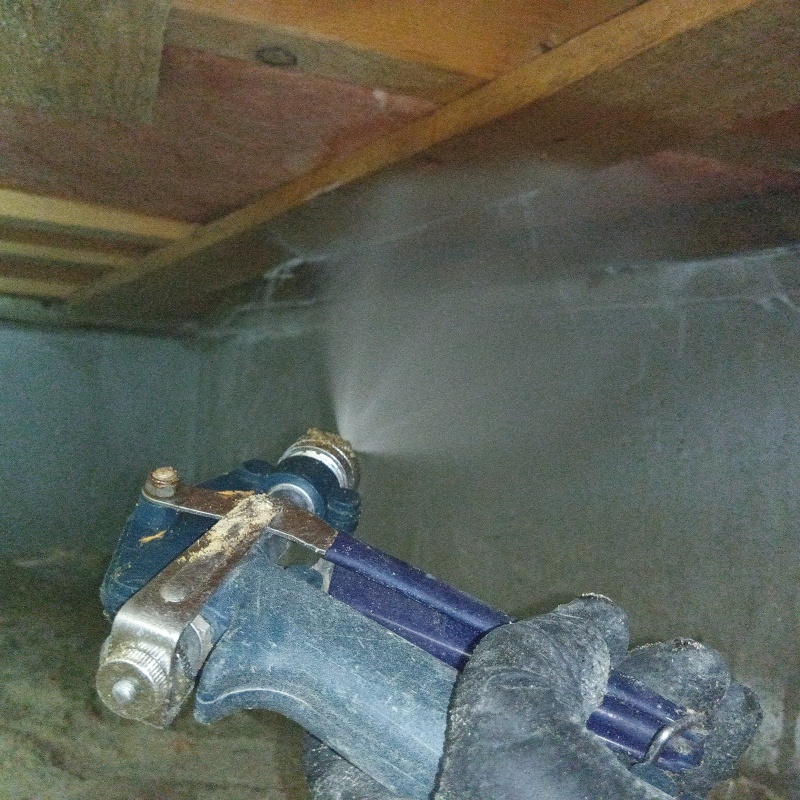 床下の木材にシロアリ駆除剤を散布する様子