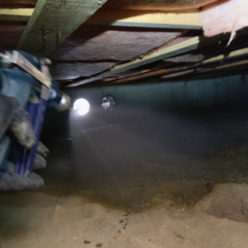 床下の土壌にシロアリ駆除剤を散布する様子