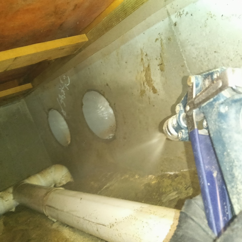 床下の土壌にシロアリ駆除剤を散布する様子