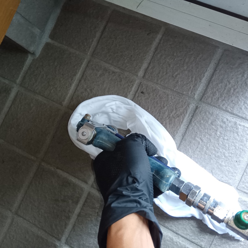 玄関の床にシロアリ駆除剤を注入する様子