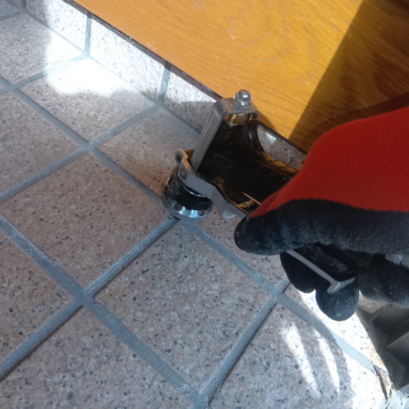 玄関のタイル部分にシロアリ駆除剤を注入する様子