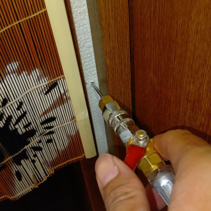 室内の壁にシロアリ駆除剤を注入する様子