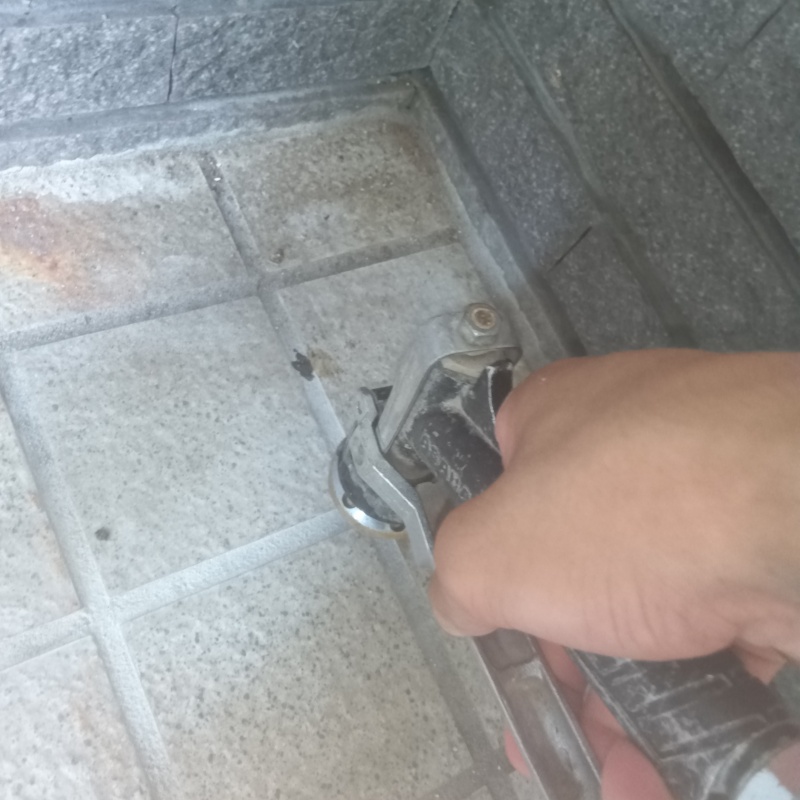 玄関の床にシロアリ駆除剤を注入する様子