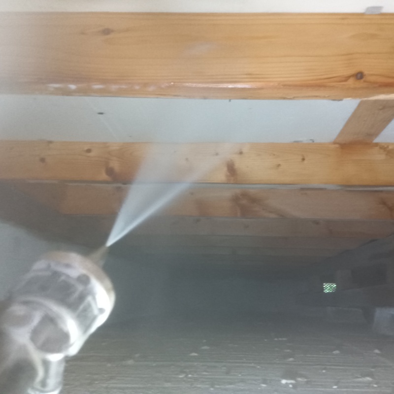 床下の木材にシロアリ駆除剤を散布する様子