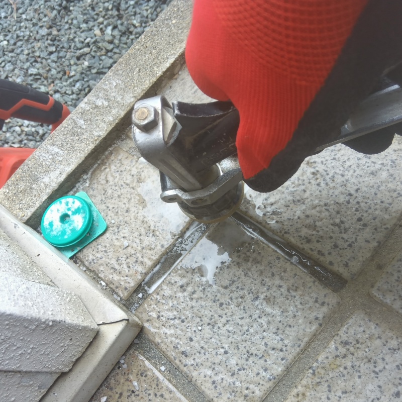 玄関のタイル部分にシロアリ駆除剤を注入する様子