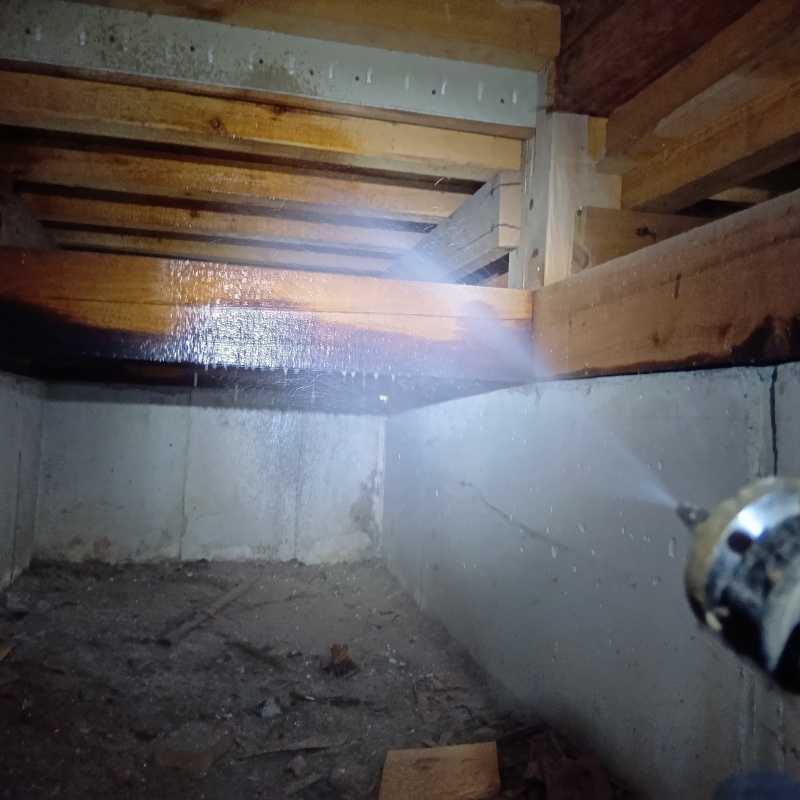 床下の木材にシロアリ駆除剤を散布する様子