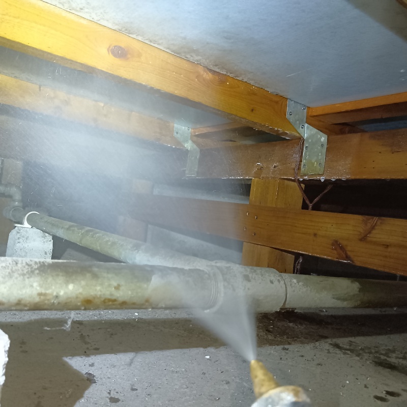 床下の木材にシロアリ駆除剤を散布する様子