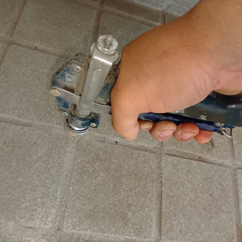 玄関の床にシロアリ駆除剤を注入する様子