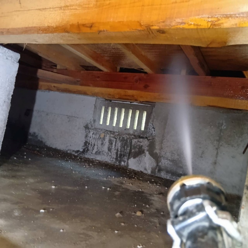 床下の木材にシロアリ駆除剤を散布する様子