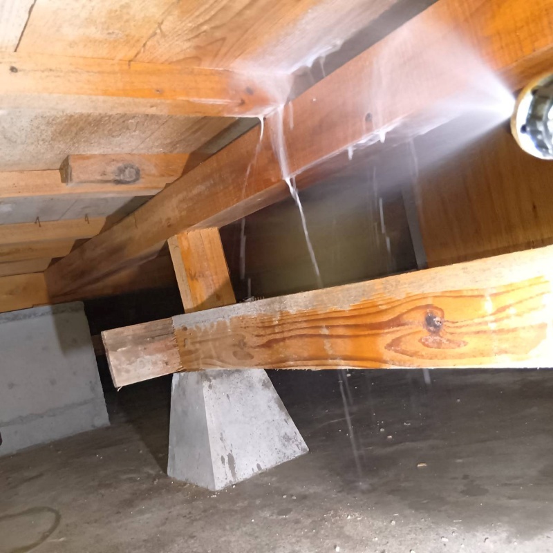 床下の木材にシロアリ駆除剤を散布する様子