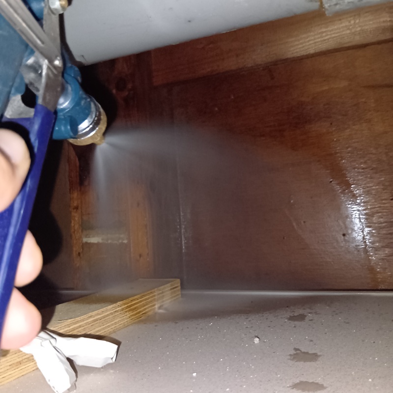 屋内の床にシロアリ駆除剤を散布