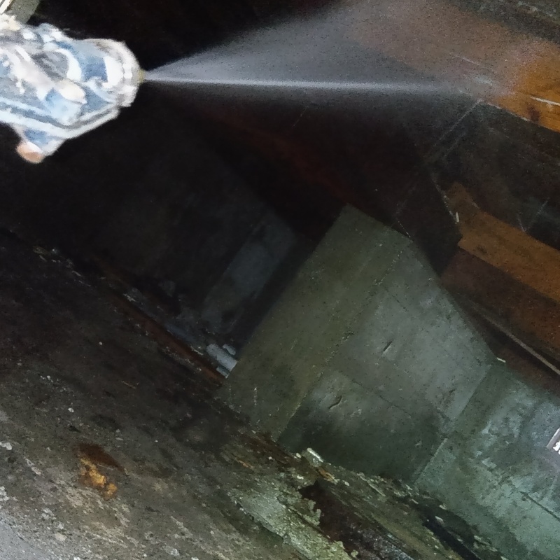 床下木材にシロアリ駆除剤を吹き付ける様子