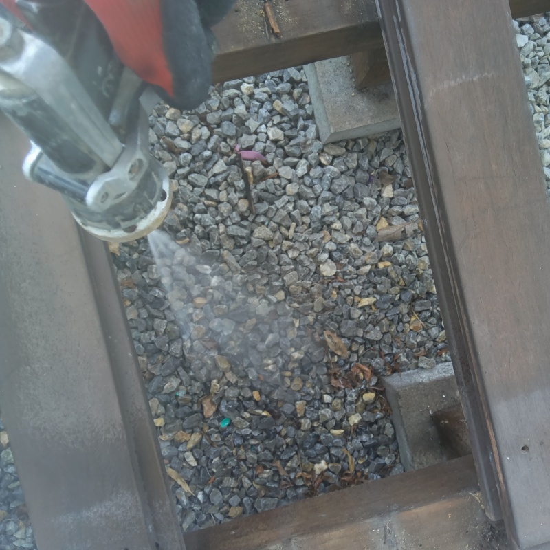 建物外周の土壌にシロアリ駆除剤を吹き付ける様子