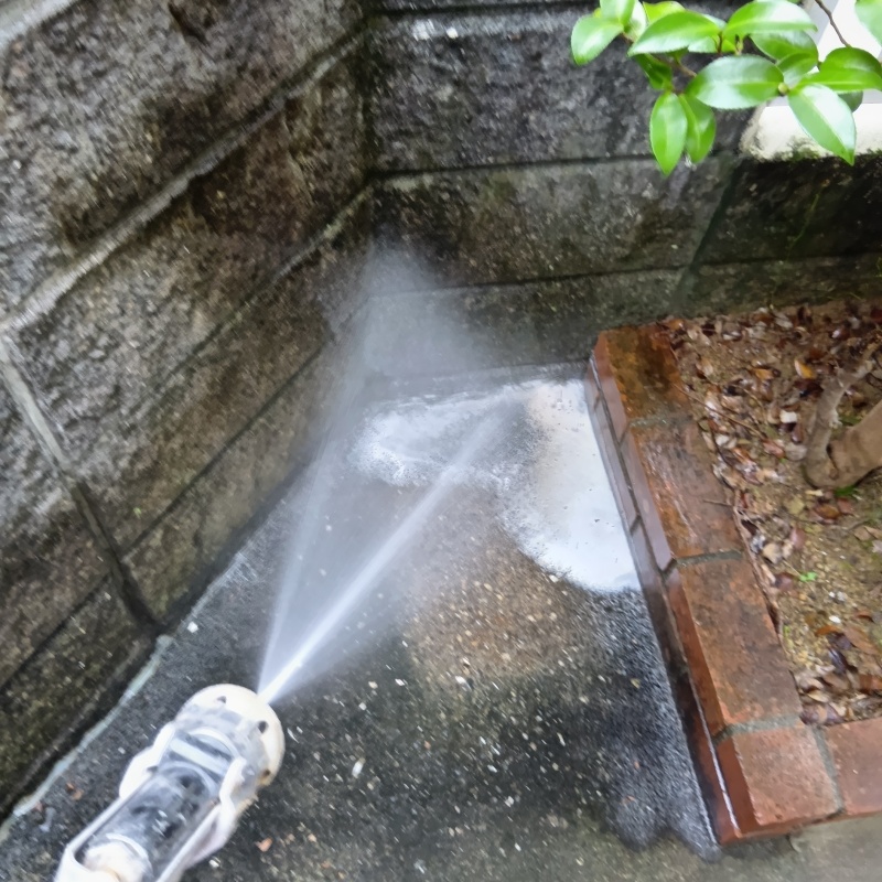 建物外周の土壌にシロアリ駆除剤を吹き付ける様子