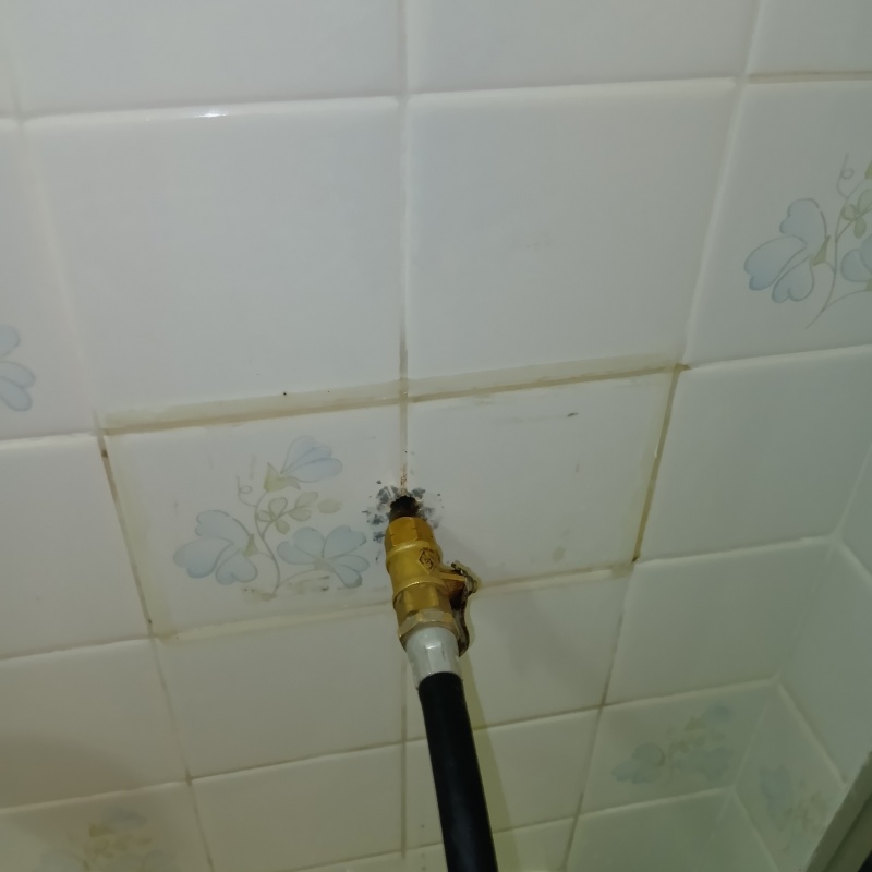 トイレの壁の目地からシロアリ駆除剤を注入