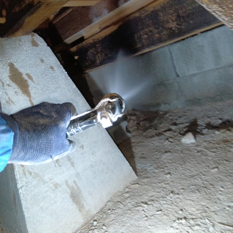 基礎にシロアリ駆除剤を吹き付ける様子