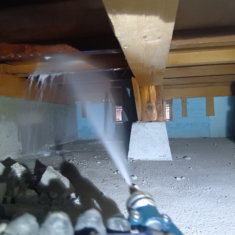 床下木材に防蟻剤を吹き付ける様子