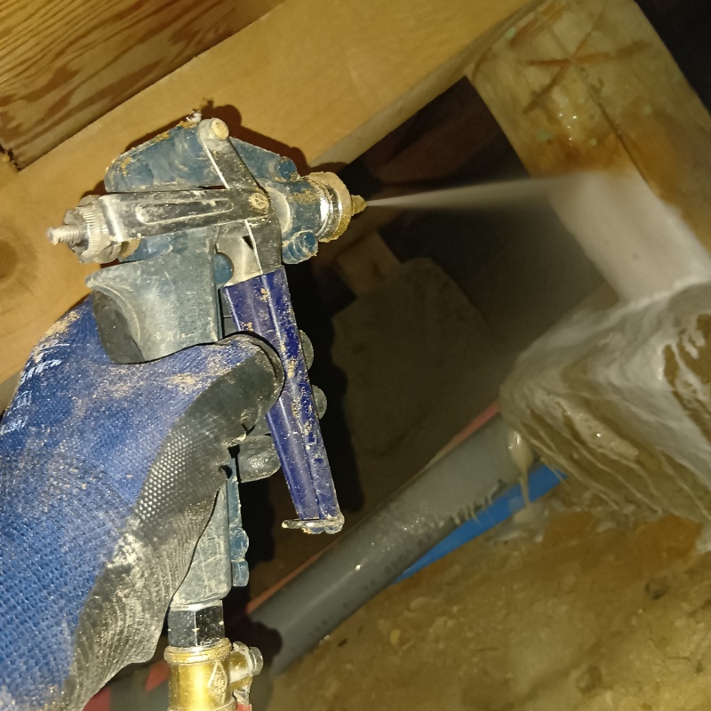 床下木材にシロアリ駆除剤を吹き付けている様子